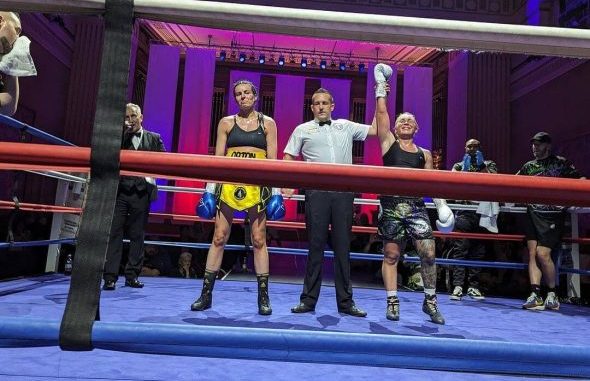 Ashleigh Johnson having her arm raised by the referee.