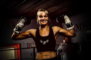 Louise Orton flexing her arms and smiling.