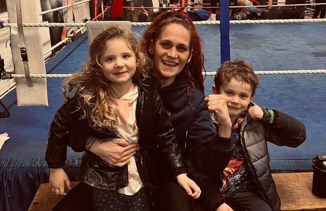 Beccy Ferguson and her two children, Cassian and Sienna, in a boxing gym.