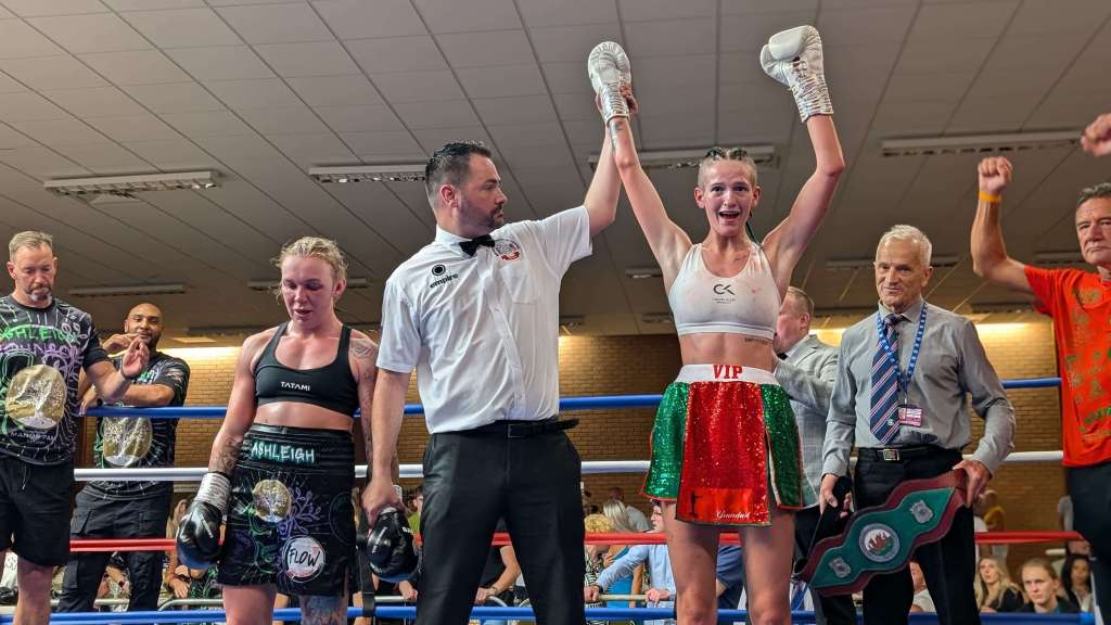 Victoria Perkins having her arm raised by the referee as it's announced that she's the first ever women's Welsh Champion.